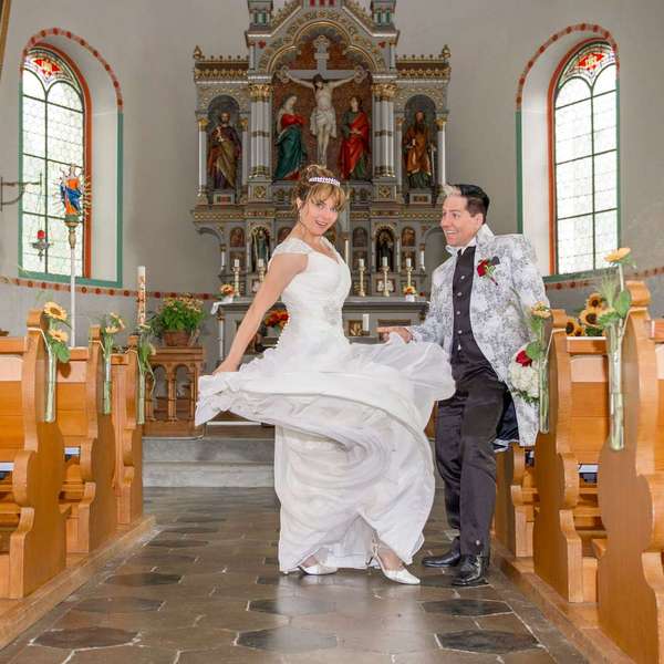 Ein lächelndes Brautpaar tanzt in einer Kirche mit Hochzeitskleidung Hochzeit-Tanz-Stunden