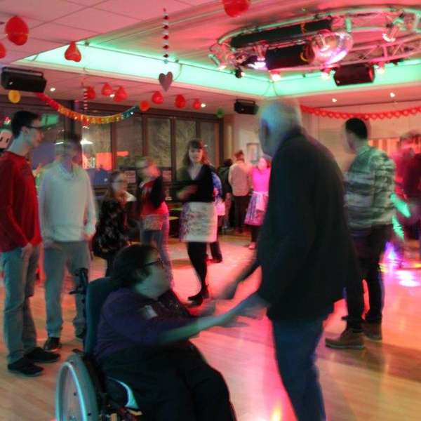 Eine inklusive Tanzparty, bei der sich Menschen in Rollstühlen und stehende Tänzer miteinander bewegen Integratives Tanzen – Tanzen für alle bei Tanzschule No.10