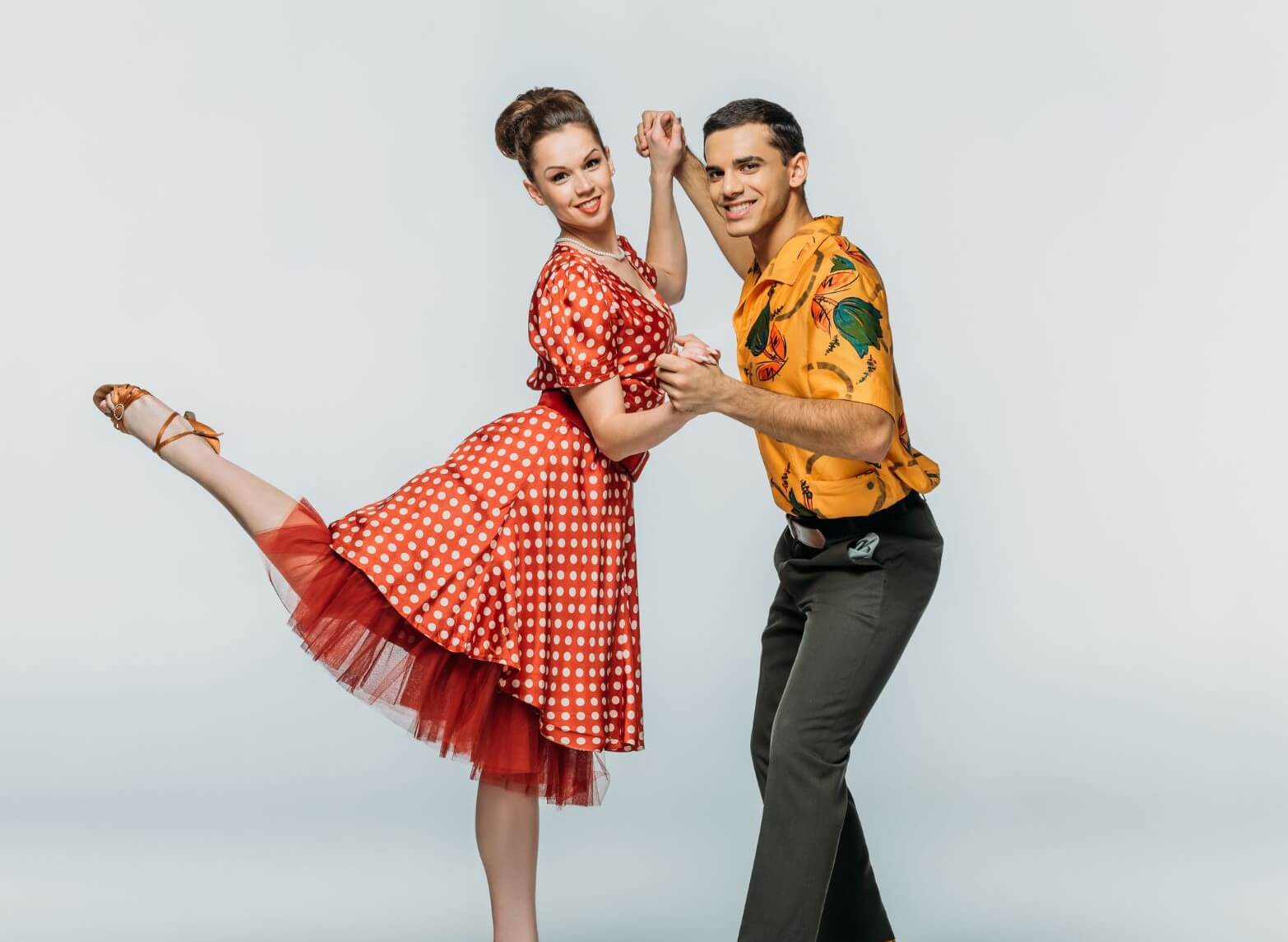 Ein Tanzpaar in Boogie-Woogie-Kleidung posiert dynamisch für die Kamera