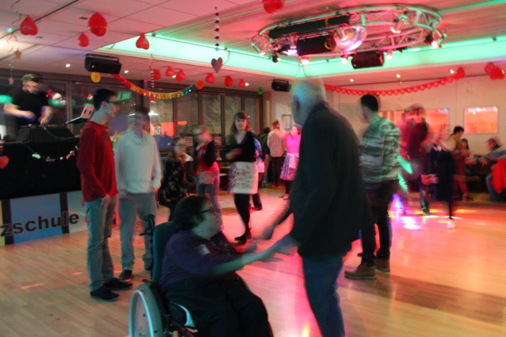 Eine inklusive Tanzparty, bei der sich Menschen in Rollstühlen und stehende Tänzer miteinander bewegen Integratives Tanzen – Tanzen für alle bei Tanzschule No.10